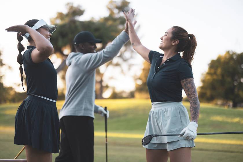 women high five golfing oahu